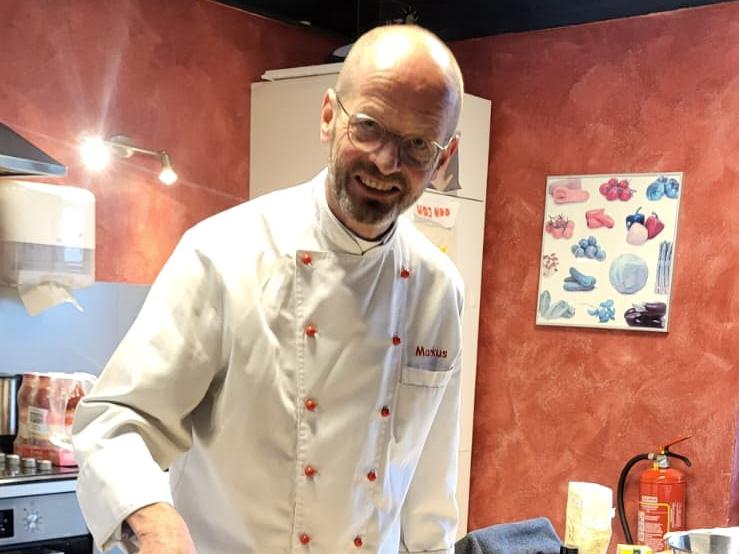 Pfarrer Markus Hoitz backt mit den Besuchenden Pizza